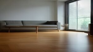 Robô aspirador moderno realizando a limpeza em uma sala de estar com piso de madeira, iluminada por luz natural.